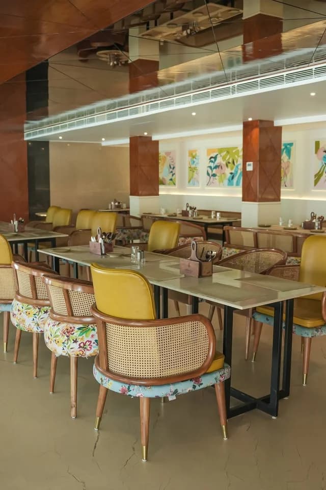 Fine dining room with warm wood and mustard chairs